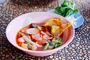 Close up of noodle in pink broth Yentafo