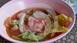 Close up of noodle in pink broth  Yentafo