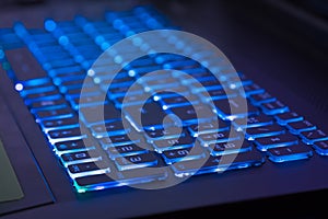 Close-up of notebook keyboard with blue light tint