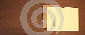 Close-up notebook or note book diary with a pen or pencil on top view wooden desk