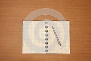 Close-up notebook or note book diary with a pen or pencil on top view wooden desk