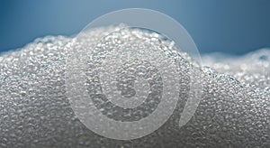 Close-up of numerous small, translucent foam bubbles densely packed together. The