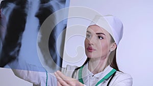 Close-up nurse looking at x-ray of patient langs.