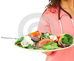 Close-up of a nurse in pink scrubs holding salad