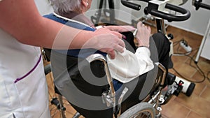 Close up nurse touch shoulder of elderly patient woman in wheelchair supporting her showing empathy and compassion