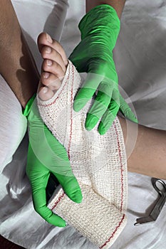 Close-up Of A Nurse Tying Bandage On Patient`s Foot,