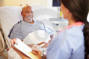 Close Up Of Nurse Updating Patient Notes