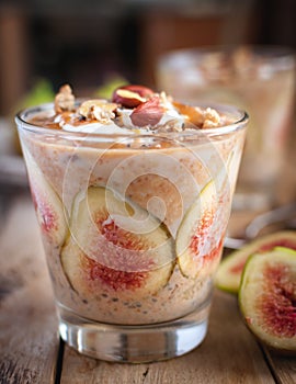 Close-up of oats and chia seeds pudding with figs, on wooden background