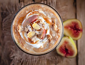 Close-up of oats and chia seeds pudding with figs, on wooden background, top view