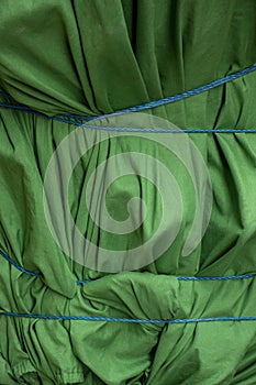 Close up of object wraped and protected with roped tide green fabric tarp and ready for transport