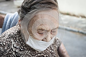 close-up of an octogenarian woman walking around in a wheelchair