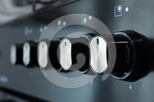Close-up of a gas stove control panel knobs in a home kitchen