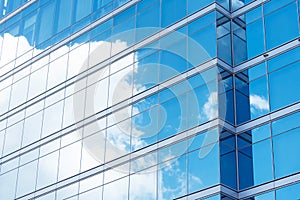 Close up of office building with reflection of blue sky and cloud. Business background.