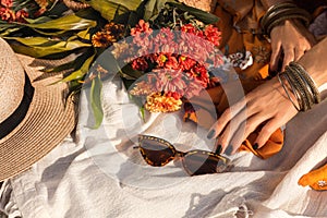 Close up oh woman hand with bohemian style accessories. picnic concept