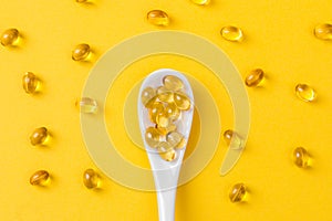 Close up of  oil filled capsules on spoon suitable for: fish oil, omega 3, omega 6, omega 9,  vitamin A, vitamin D, vitamin D3,