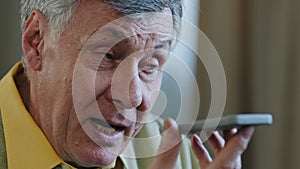 Close-up old 60s caucasian man grandfather elderly businessman aged 70s male holding mobile phone speaking into