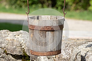 Close up of a old antique wooden bucket hanging over a well