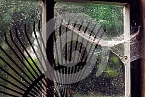 Close-up of Old Barn Window with Rake and Cobwebs