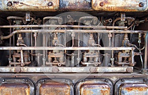 Close up of an old big rusting diesel combustion engine with cylinders rods and pipes