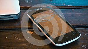 Close up of old and broken mobile phone on wooden table