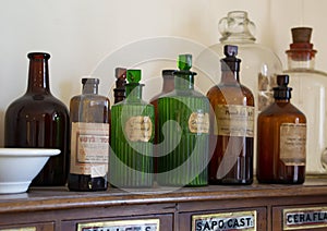 North Wales, UK 4th Sept 2018 Close-up of old brown and green glass medicine bottles on drawer cabinet with labels