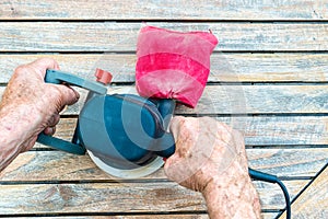 Close-up of old carpenter`s hands working with electric sander