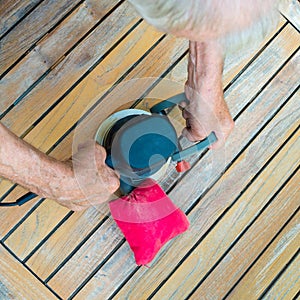 Close-up of old carpenter`s hands working with electric sander