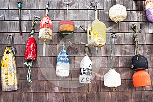 Close up of old colourful fishing buoys hanging on a wooden wall