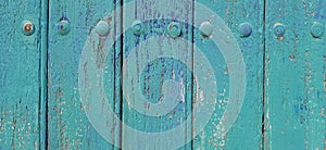 close up old door wooden texture background, door with antique rivets, door made of wood material, door painted green and blue