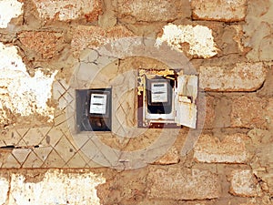 Close up of old electricity meters on stone facade from Berber culture in Sinai Peninsula. Religions and