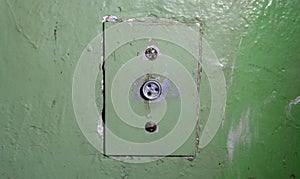 Close-up of old elevator button. Ancient soviet button on concrete wall with dirty and peeling paint.