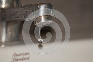 Close up old faucet with water drop background.