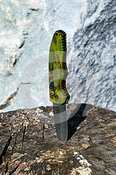 Close-up of an old folding army knife on a wooden surface background