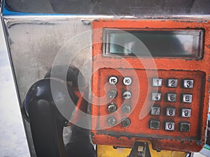 Close up Old Grungy Orange Public Payphone