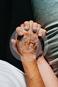 Close up of an old hand grabbing a young hand on cinematic tones