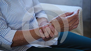 Close up of old hands senior woman massaging from joint pain and feeling hurt. Older grandmother having rheumatoid