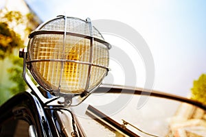 Close up of old head light on rarity black car