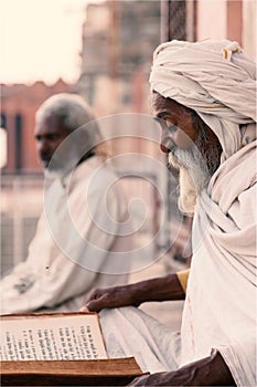 Close up of a old indian sadhu reading scriptures.