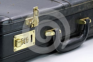 Close up of an old leather briefcase with golden combination lock