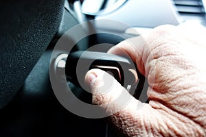 Close up of old man hand turning on the car engine