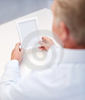 Close up of old man holding blank photo frame