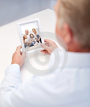 Close up of old man holding happy family photo