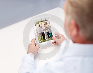 Close up of old man holding happy family photo