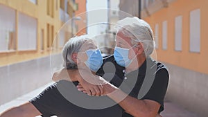 Close up of old and mature woman and man at home holding keys of house to the camera. Portrait of couple of senior smiling and loo