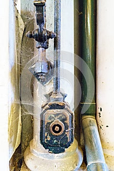 Close-up of an old mechanism part of the system for raising and lowering awnings and blinds covered with spider webs and an old gr