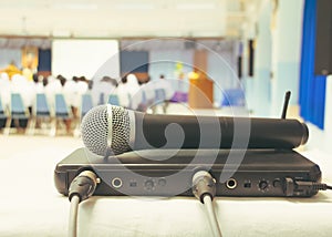 Close up old microphone wireless with box signal on the white table in business conference interior seminar meeting room