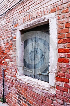 Close up old red brick wall building with shutters window concept photo. Street scene,