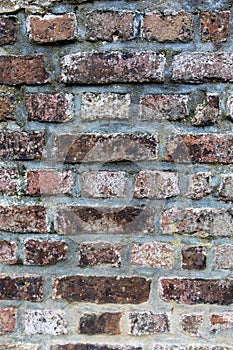 Close up of an old red orange brown worn and weathered brick wall, clinker bricks. Brick texture