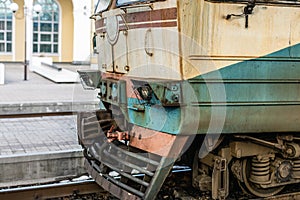 close-up Old rusty diesel train locomotive at railway station. Outdated technology cargo transport vehicle