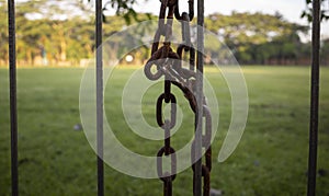 Close up of an old rusty metal padlock and chain, in shalow focus